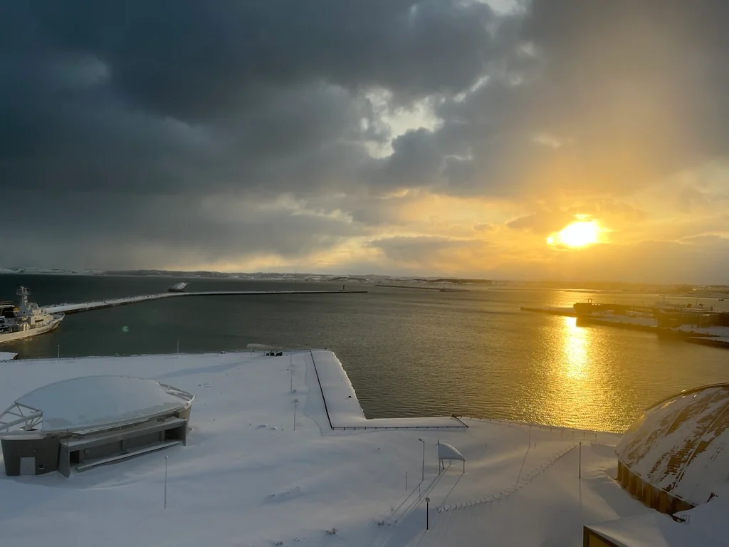雪の港に夕日が差し込む風景